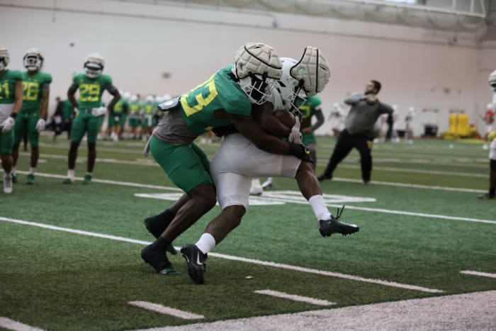 Oregon linebacker Jeffrey Bassa (33) wraps up running back Noah Whittington during spring practice.